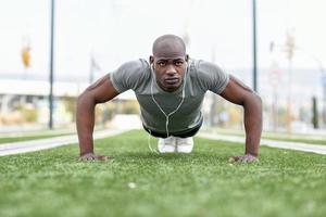 fitness uomo nero esercizio push up in background urbano foto