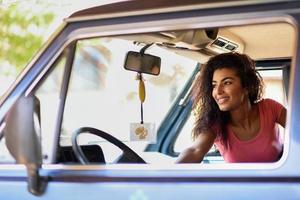 ragazza araba all'interno di un vecchio furgone parcheggiato in un campeggio in mezzo alla natura foto