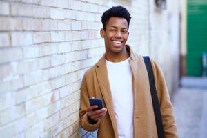 giovane uomo di colore che usa il suo smartphone all'aperto. foto