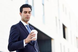 uomo d'affari che beve caffè per andare con una tazza da asporto foto