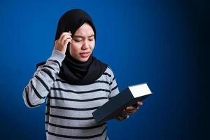 donna musulmana malata e stanca che legge troppi libri foto