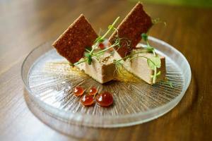 piatto di foie micuit con crostini croccanti e gocce di marmellata. foto