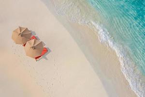 vista aerea della splendida spiaggia con ombrelloni e lettini vicino al mare turchese. vista dall'alto del paesaggio estivo della spiaggia, vacanza idilliaca di coppia ispiratrice, vacanza romantica. viaggio in libertà foto