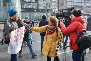 Mosca, Russia - 10 marzo 2019. giornalista televisiva femminile che intervista un giovane manifestante che tiene uno striscione politico foto