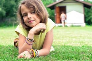 simpatica studentessa sdraiata sul prato con i braccialetti dell'amicizia ai polsi. foto