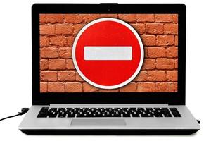 laptop con il cartello stradale non entrare e un muro di mattoni rossi sullo schermo foto