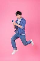 giovane uomo asiatico che salta su sfondo blu foto