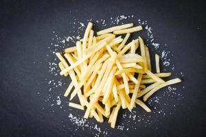 patatine fritte fresche con sale su piatto nero, spazio copia vista dall'alto - gustose patatine fritte per cibo o spuntino delizioso menu italiano fatto in casa foto