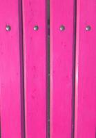 tavole dipinte con vernice rosa staccionata in legno con rivetti in metallo, parete, sfondo verticale foto