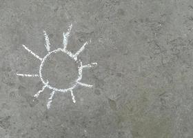 il sole è disegnato con il gesso sull'asfalto. estate. posto banner per testo, creatività per bambini foto