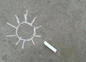 il sole è disegnato con il gesso sull'asfalto. estate. posto banner per testo, creatività per bambini foto