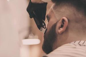uomo barbuto in un negozio di barbiere foto