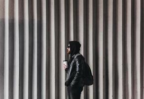 uomo alla moda con tazza di caffè e zaino foto