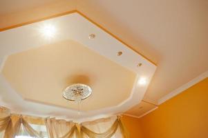 lampadario dorato e specchio con luce puntiforme su soffitto arancione foto
