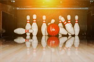 dieci birilli bianchi in una pista da bowling con palla colpita foto