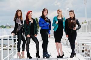cinque belle ragazze giovani modelli in giacche di pelle in posa sull'ormeggio. foto