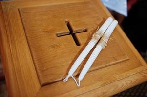 due candele al petto di legno con croce in chiesa foto