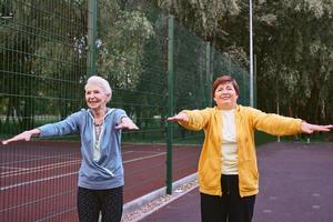 due donne mature che fanno esercizi sportivi nel parco. concetto di stile di vita sano foto