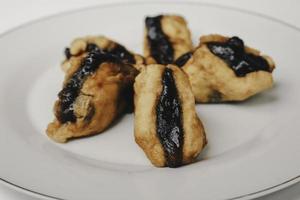 tofu o tahu fritto con salsa petis in platebackground bianco, spuntino indonesiano tradizionale giavanese foto