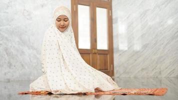 le donne musulmane asiatiche eseguono le preghiere obbligatorie nella moschea foto