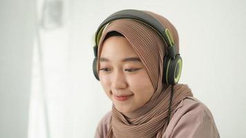 bella donna asiatica in hijab che ascolta attentamente foto