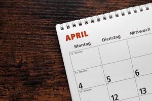 mese di aprile nel calendario o pianificatore tedesco sulla scrivania di legno foto