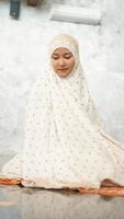 le donne musulmane asiatiche eseguono le preghiere obbligatorie nella moschea foto