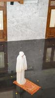 donna musulmana asiatica che prega da sola senza imam nella moschea foto