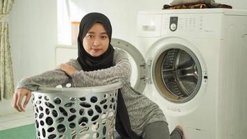 giovane donna asiatica che si prepara a fare il bucato a casa foto