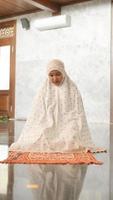 donna musulmana asiatica che prega nella moschea foto