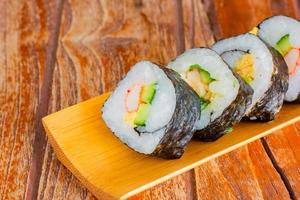 tamagoyaki maki con involucro di alghe su vassoio di legno. delizioso cibo giapponese.