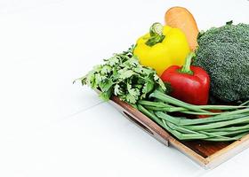 broccoli e peperoncino e cipolla e verdura mista di carote su cesto di legno foto