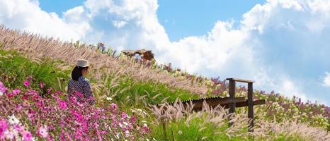 donna che cammina nel giardino di fiori in estate foto