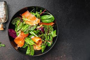 fette di insalata di salmone pesce mix di insalata verde foglie frutti di mare fresco pasto sano cibo sfondo foto
