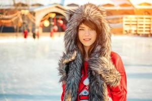 ritratto di una bella ragazza alla pista di pattinaggio in inverno foto