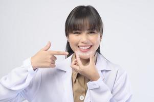 giovane dentista femminile che tiene parentesi graffe invisalign su sfondo bianco studio, assistenza sanitaria dentale e concetto ortodontico.