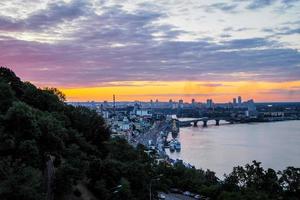 kiev, ucraina - 4 luglio 2019. panorama della città di kiev, ponte di osservazione sul dnipro, cielo al tramonto sullo sfondo forma la bandiera dell'ucraina. sfocato foto