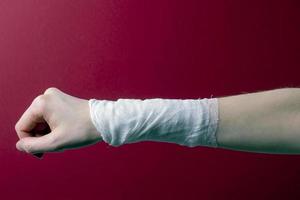 la mano della donna fasciata con una benda medica foto