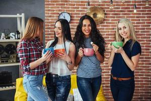 gruppo di bei giovani che si divertono in una conversazione e bevono caffè, migliori amiche ragazze insieme divertendosi, in posa concetto di stile di vita emotivo foto