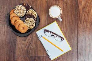 vista dall'alto di taccuino, cancelleria, strumenti di disegno e alcune tazze di caffè. foto