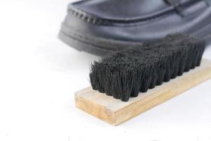 pulire le scarpe con una spazzola sul pavimento foto