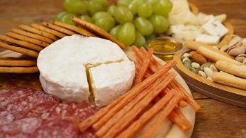 diversi gustosi antipasti su fondo di legno. concentrarsi sul formaggio camembert foto