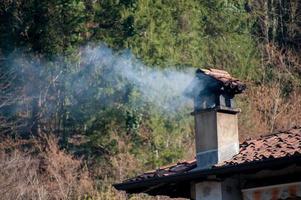 camino fumante dalla stufa a legna foto