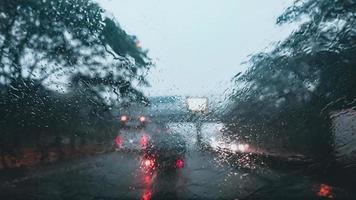 foto sfocata del parabrezza con forti piogge, modulo di visualizzazione all'interno di un'auto che guida