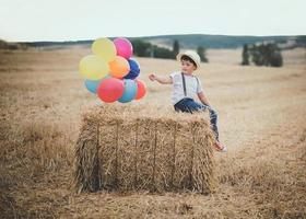 bambino felice con palloncini nel campo foto