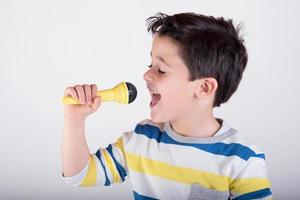 ragazzo che canta con un microfono foto