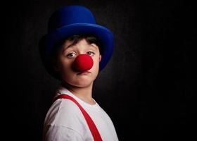 bambino divertente con naso e cappello da clown foto