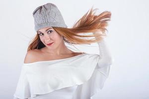 sorridente e divertente giovane donna con cappello invernale su sfondo bianco foto