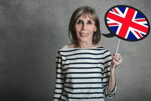 donna anziana che tiene un cartello con la bandiera inglese foto