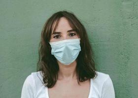 primo piano di una giovane donna che indossa una maschera medica foto